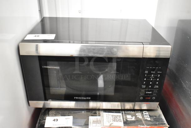 Frigidaire FFCM1155US microwave oven, black with stainless trim. Features digital keypad, 120 volts, with plate. Good condition.