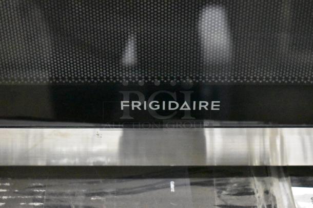 Frigidaire FFCM1155US microwave oven, stainless steel, includes plate, 120V, model label visible.