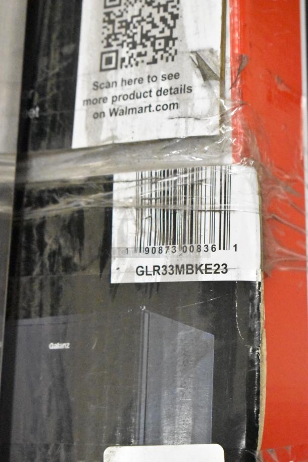 Brand new Galanz GLR33MBKE23 mini cooler in box. Features 115 volts, 1 phase. Visible barcode and QR code for details.