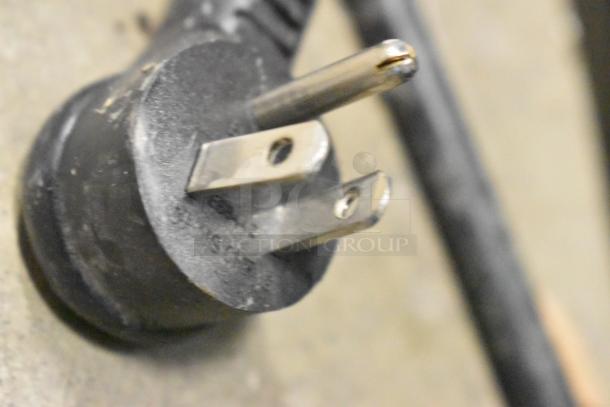 A close-up of a power plug for True GDM-12-HC-LD commercial cooler, showing three-prong electrical connector.