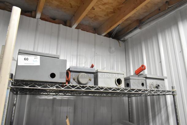 Five metal power boxes on a shelf with visible conduit openings and red handles, marked "60" for auction, in used condition.