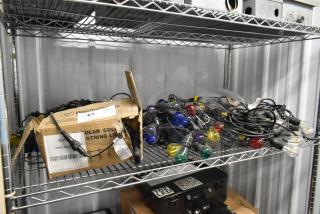 Five sets of multicolored string lights on metal shelves. Includes Westinghouse box, indicating solar lights. Good condition.