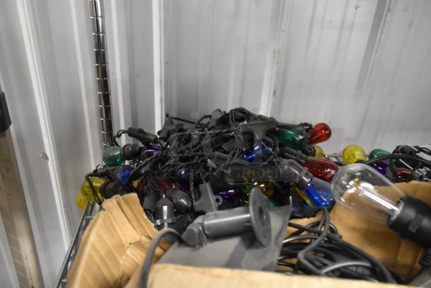 Multicolor 5-string lights in box, various bulb colors, bundled cords. Ideal for decorative use. Condition appears used.