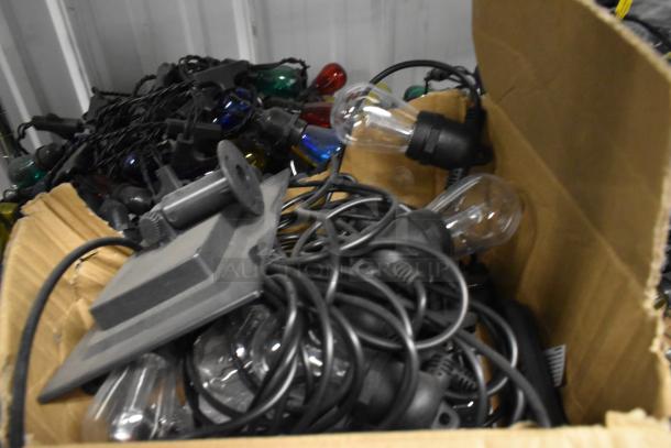 Box of assorted 5 string lights, various colored bulbs, tangled cords, used condition. No visible brand markings.