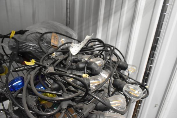 Tangled string lights with black wiring and clear, multicolored bulbs. Includes five sets. Condition appears used.