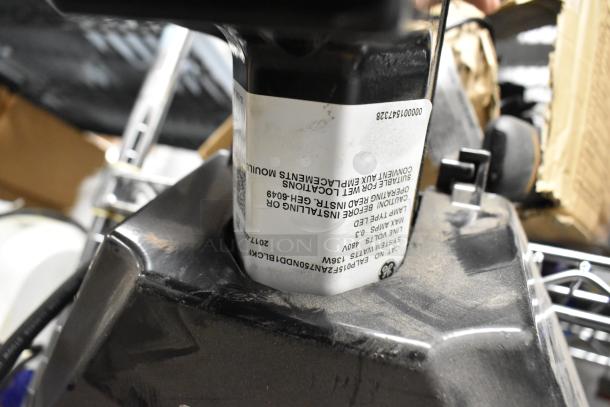 Four flood lights with visible GE label, suitable for wet locations. Black casing, appears slightly dusty. Model: GEH-6049.