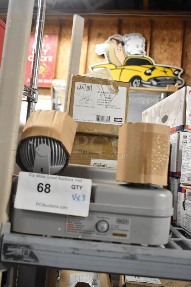 Three boxed items on a shelf, including Dual Lite Double Remote Head and DYN6I-WM Emergency Light. Auction tag visible.