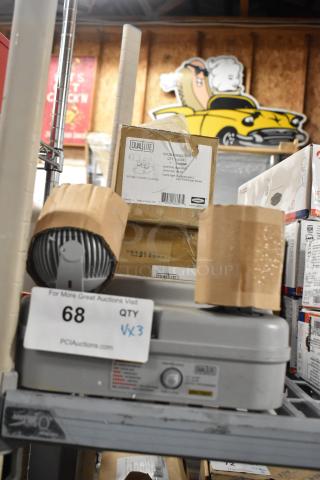 Three boxed items on a shelf, including Dual Lite Double Remote Head and DYN6I-WM Emergency Light. Auction tag visible.