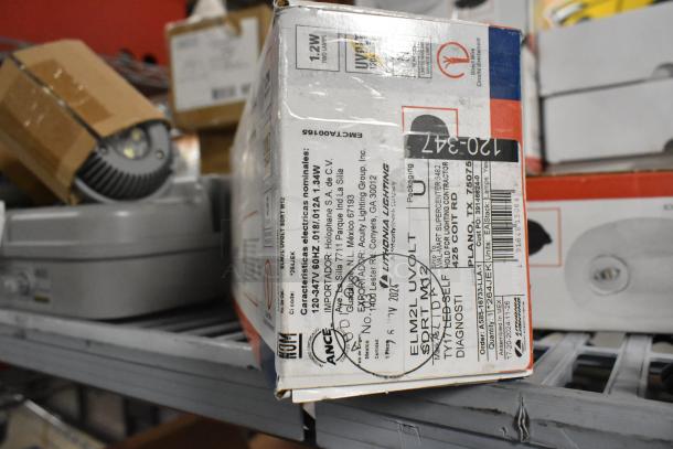 Box of Lithonia Lighting emergency lights and exit signs, labeled as 12W, new condition, 9 times your bid.