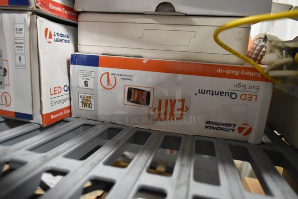 Lithonia Lighting emergency lights and LED exit signs in boxes, new condition, remote capable, dual voltage.