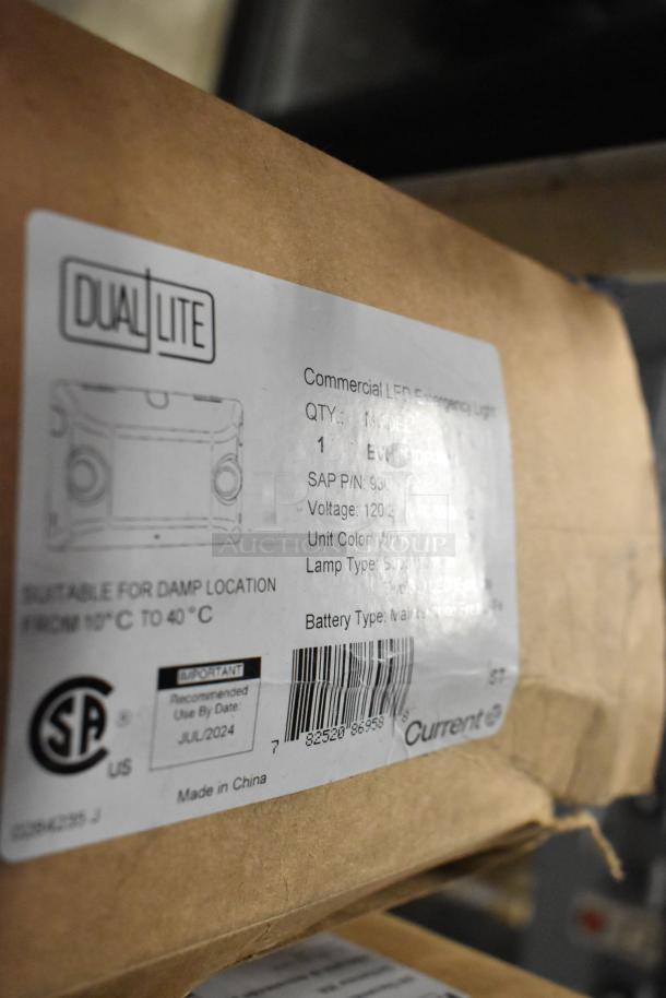 Dual Lite emergency light with model label showing features: 120V, white unit, suitable for damp locations, use by July 2024.