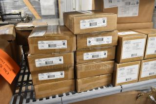 Nine new Dual Lite EVHCEZP commercial LED emergency lights in boxes, labels showing model and certifications.