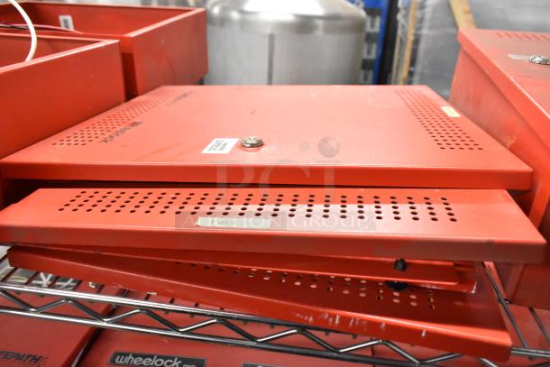 Three Wheelock PS-8 Powerpath NAC Extenders in red, used condition, with perforated casing and visible labels.