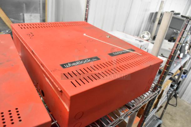 3 Wheelock PS-8 Powerpath NAC Extenders, red casing, minor wear, "Wheelock Inc." label, stored on metal shelving.