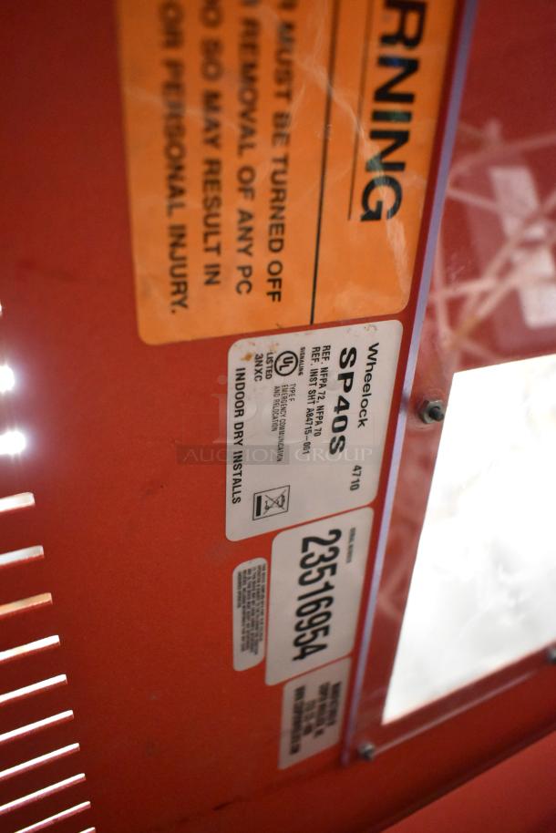 Wheelock SP40S Safepath voice evacuation panel with detailed label showing model and installation info on red panel surface.