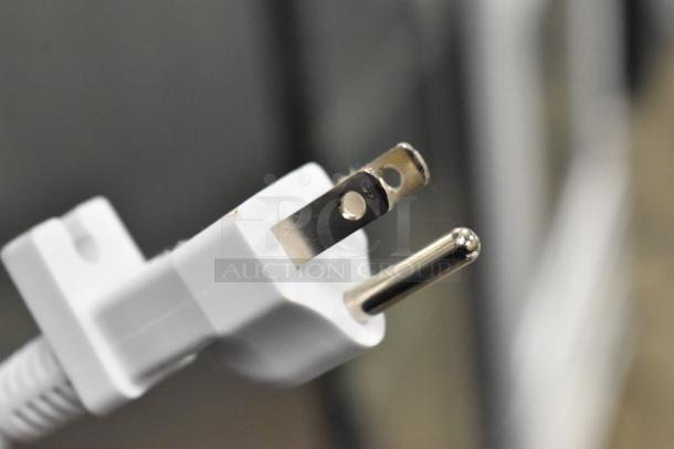 Close-up of a white plug for a towel warmer, 115 volts, 1 phase, in good condition.