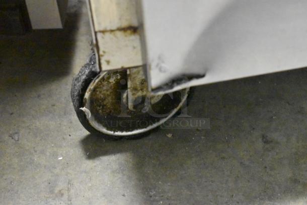 Alto Shaam 750-S heated holding cabinet caster, showing wear and some rust, on a concrete floor.