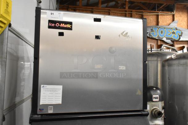 Ice-O-Matic ICE1006HW7 commercial ice machine head on bin. Stainless steel, 208-230V, 1 phase. Manufacturer sticker visible.