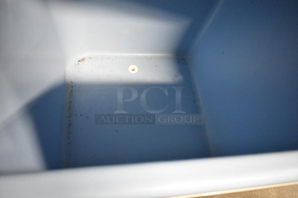 Interior of Ice-O-Matic ICE1006HW7 ice bin showing used condition. Clean, durable plastic with minor residue at corners.