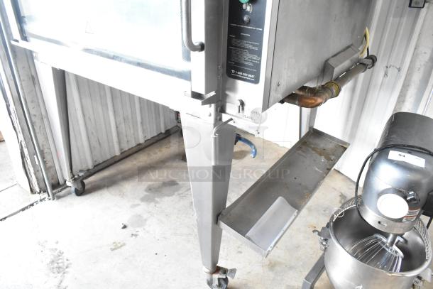 Hardt Inferno 3500 stainless steel rotisserie oven, gas-powered, with skewers and metal legs on casters, good condition.