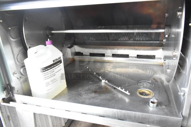 Hardt Inferno 3500 stainless steel rotisserie oven, natural gas powered, includes skewers and metal legs on commercial casters.