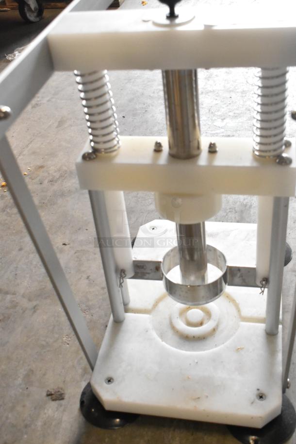 Countertop pineapple corer with stainless steel components and sturdy plastic base, in good condition; ideal for easy fruit preparation.