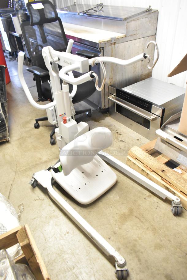 Sabina II Sit To Stand Patient Lift with adjustable armrests and padded leg support, in good condition.