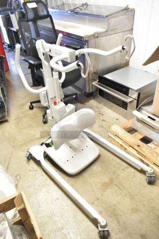 Sabina II Sit To Stand Patient Lift with adjustable armrests and padded leg support, in good condition.