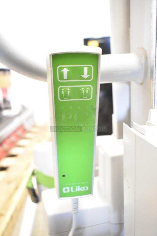 Sabina II Sit To Stand Patient Lift by Liko, featuring a green control panel with directional icons, in excellent condition.