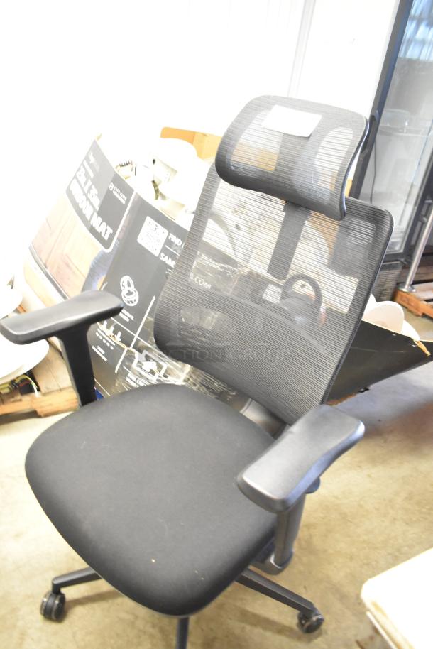 Black office chair on casters with mesh backrest and padded seat. Adjustable armrests. Good condition.