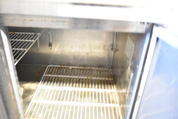 Avantco 178PICL2 stainless steel pizza prep table interior with wire shelving, on commercial casters, 115V, 1 phase.