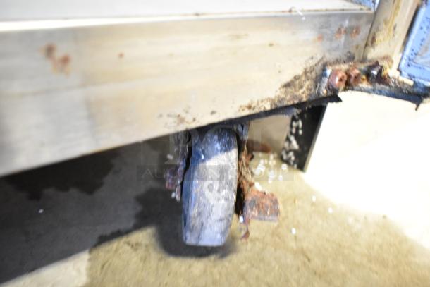 Rusted caster wheel on Avantco 178PICL2 stainless steel pizza prep table, showing wear and corrosion.