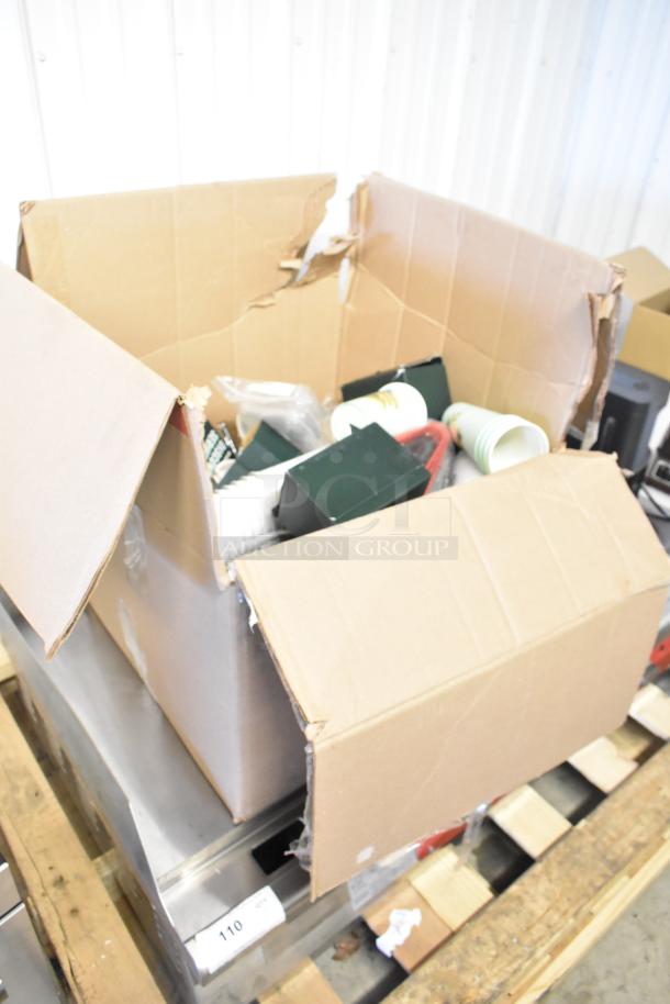 Open box with assorted items including Discovery Series mug and cups, some in packaging; box in worn condition.