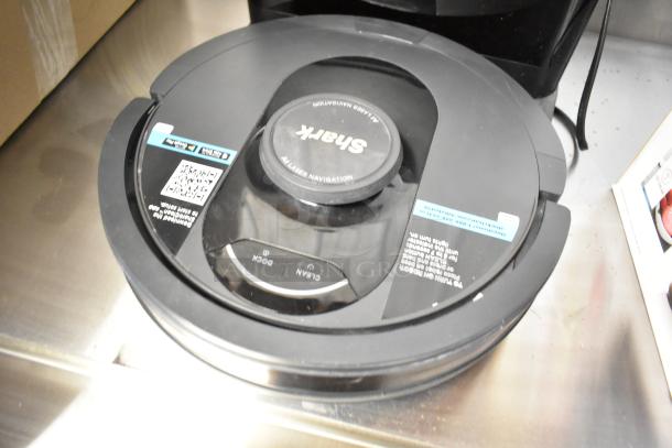 Shark robot vacuum cleaner with docking station, 120V, laser navigation, in good condition, showing control buttons and labels.