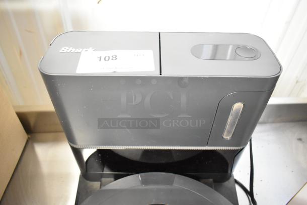 Shark Robot Vacuum Cleaner with docking station, 120V, 1 phase. Includes label "108". Slight surface wear visible.