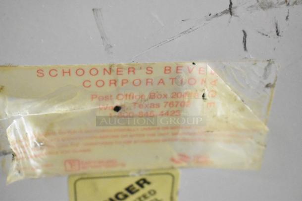 Label on metal commercial countertop slushie machine. Schooner's Beverage Corporation contact details visible.