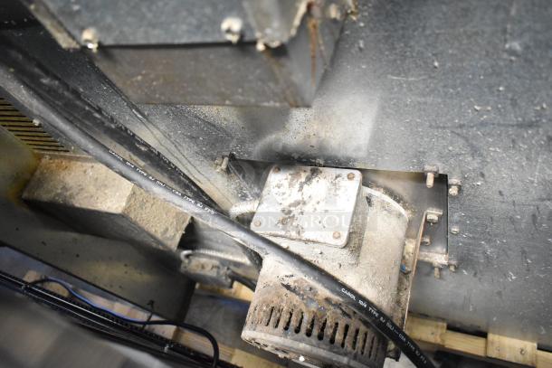 Inside view of Imperial commercial convection oven showing motor and wiring, indicating industrial use and sturdy construction.