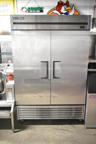 2020 True T-49F-HC stainless steel commercial 2-door reach-in freezer with poly-coated racks and commercial casters.