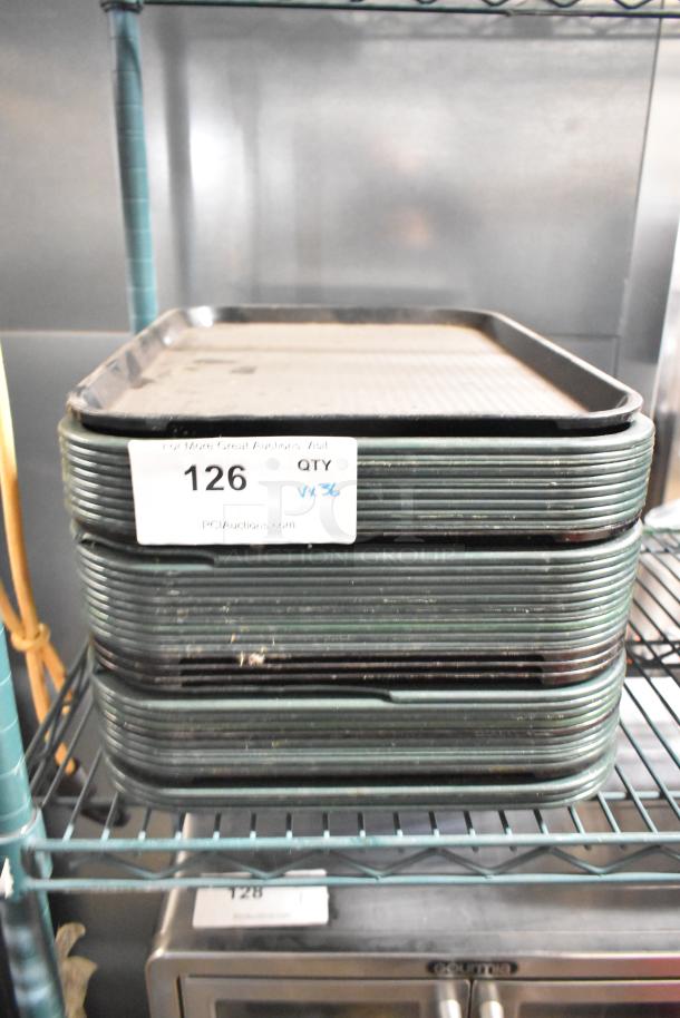 Stack of 36 poly food trays on shelf, slight wear visible. Label indicates lot number 126, quantity 36, from PCIAuctions.