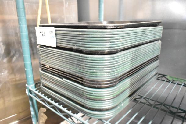 Stack of 36 poly food trays with green rims, in good condition, on metal shelf. Tag reads "126."
