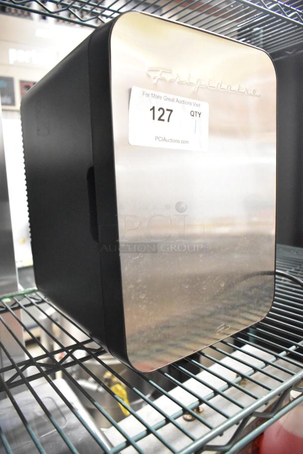 2023 Frigidaire Stainless Steel Mini Cooler, 10L, 0.35 cu. ft., 120V/12V, new condition, with Frigidaire logo and auction label.