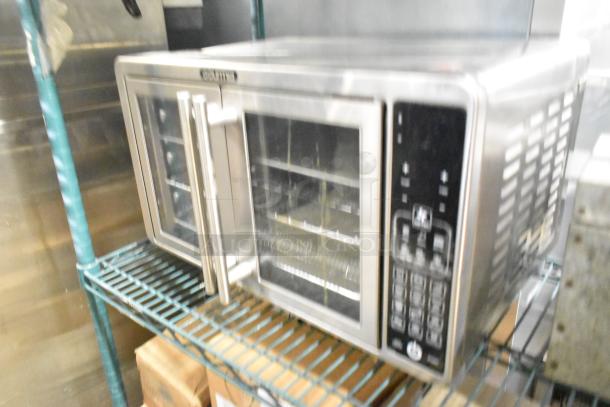 Gourmia GTF7660 digital air fryer oven in metal, 120 volts, on shelf, visible control panel, sleek design.