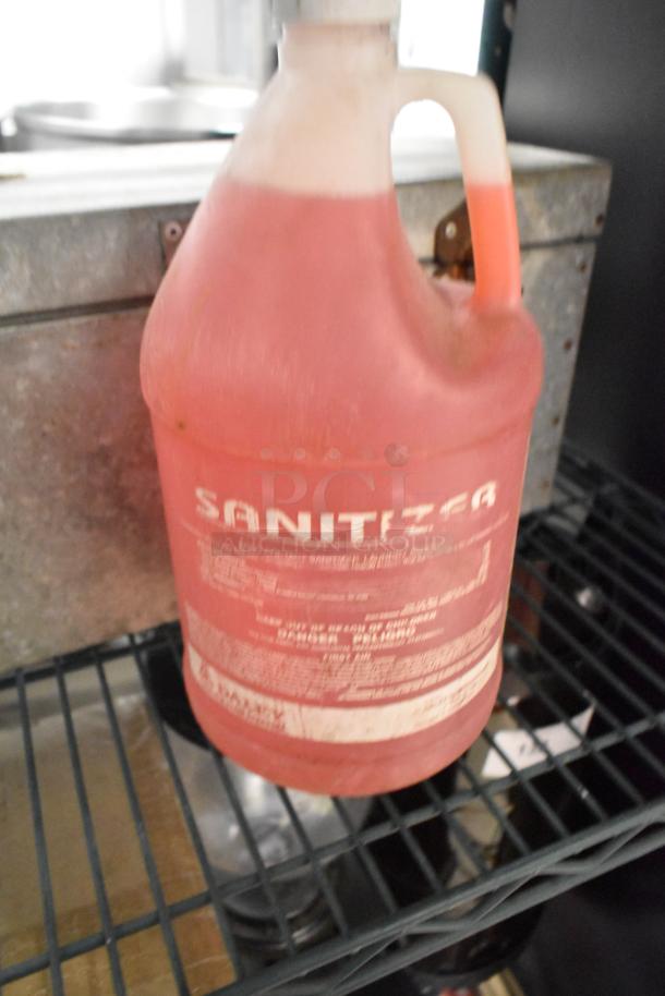 Two items: a metal tool box and a jug of red sanitizer. The tool box is metal and sturdy, and the sanitizer holds a large volume.