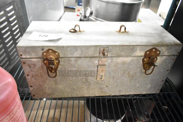 Metal tool box with rusty latches and a label marked "129." Includes jug of sanitizer. Auction lot; bid multiplier applies.