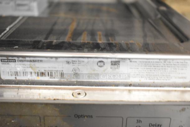 Samsung DW80M2020US undercounter dishwasher, stainless steel. Features visible labels with model and certification details.