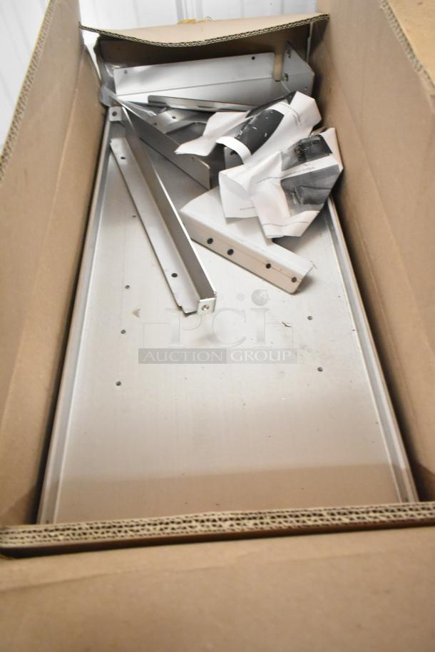 Box of various items including Hobart metal pieces and a roll of material, with worn appearance. Multiplication deal.