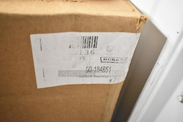 Cardboard box with Hobart label showing item ID D136 and number 00-184851, indicating metal pieces and roll of material.