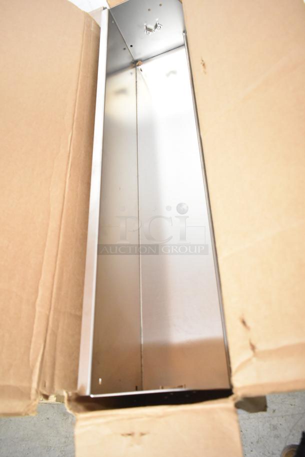 Cardboard box containing a metal piece, possibly from Hobart, in good condition. Includes a roll of material. Auction lot.