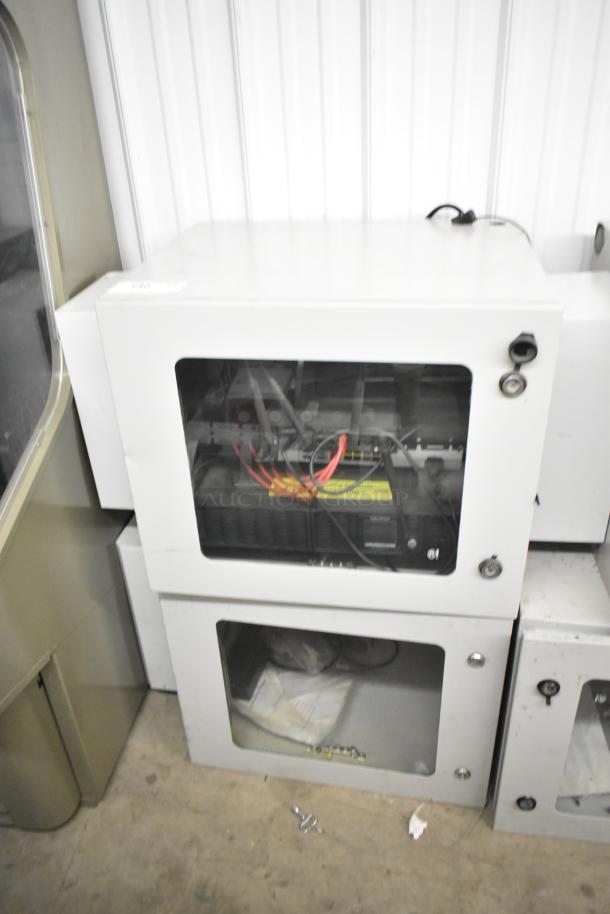 2 BlackShields DC0300 white metal cabinets with clear front panels, showing internal components. Minor wear visible.