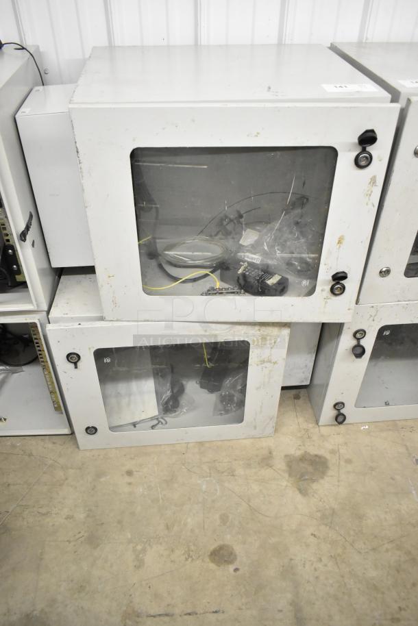 2 BlackShields DC0300 white metal cabinets with clear doors. Visible wear; used condition. Lock mechanisms on front.